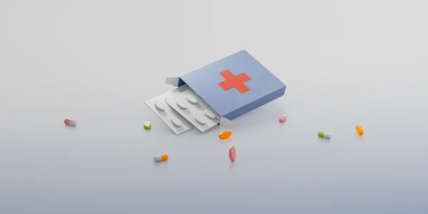 Eine geöffnete blaue Medikamentenpackung mit rotem Kreuz, aus der Blister mit runden Tabletten herausragen, umgeben von bunten Pillen und Kapseln.