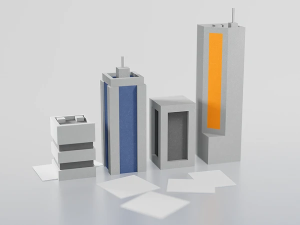 Verschiedene stilisierte Gebäudemodelle in grauen und blauen Farbtönen sowie ein orangefarbenes Element stehen auf einer glatten Oberfläche.